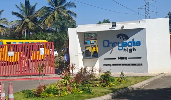A clear view of the Chrysalis High entrance signage from the main road, highlighting the prime educational zone surrounding the Sobha Hoskote development