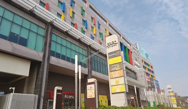Street side view of the entrance to Orion Uptown Mall showcasing easy access from Sobha Hoskote