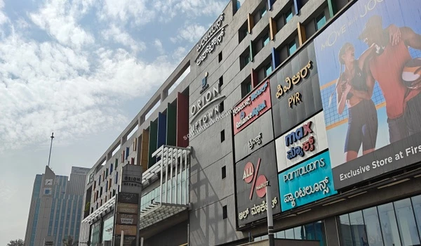 Modern architectural facade of Orion Uptown Mall featuring colorful panels near Sobha Hoskote
