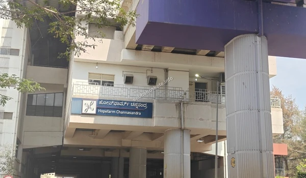 The exterior of the Hopefarm Channasandra Metro station on Whitefield Main Road, a key transit point for the Kadugodi and Channasandra neighborhoods.