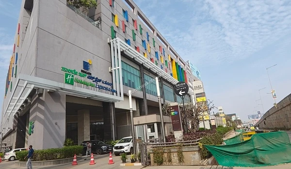 Close-up view of the Orion Uptown Mall entrance signage highlighting the prime connectivity and shopping options near Sobha Hoskote