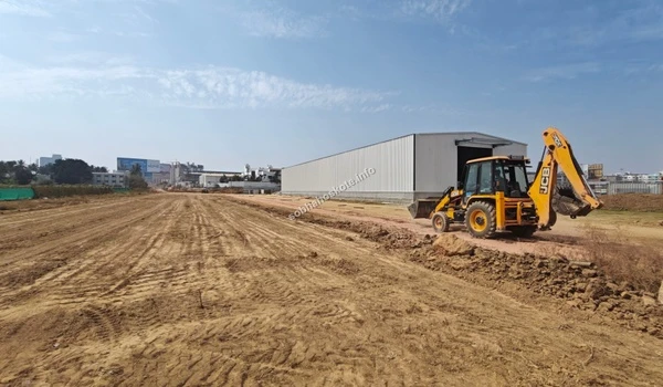 Active site work showing construction vehicles operating near the warehouse facility at Sobha Hoskote