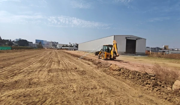 Ongoing construction workflow featuring machinery and ground crews at Sobha Hoskote