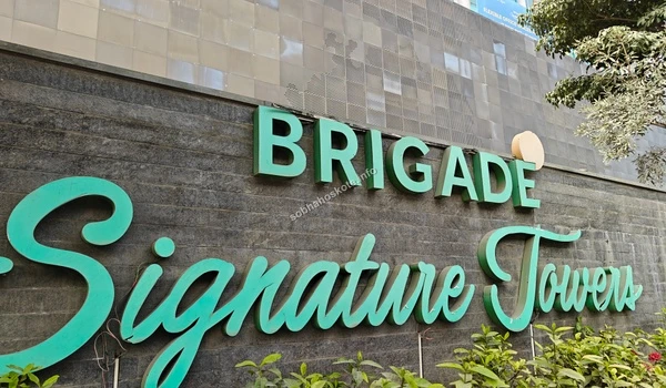 Detailed view of the landscaped entrance and corporate branding at the foot of the commercial towers near Sobha Hoskote