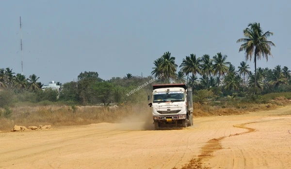 Construction vehicle moving earth at the Sobha Hoskote site during the initial excavation phase
