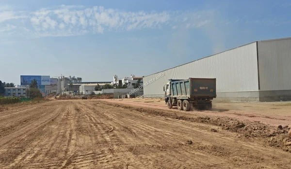 Rear view of a heavy-duty dump truck maneuvering through the prepared soil path at the Sobha Hoskote project