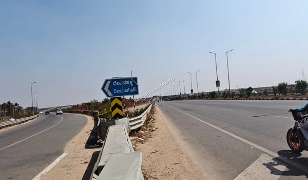General view of the modern road infrastructure and safety guardrails along the STRR towards Devanahalli, serving the growing residential hub of Hoskote