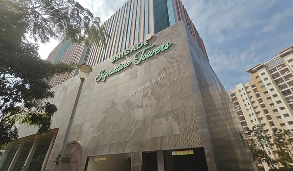 Wide view of the local language branding and artistic pillars at the tower entrance near Sobha Hoskote
