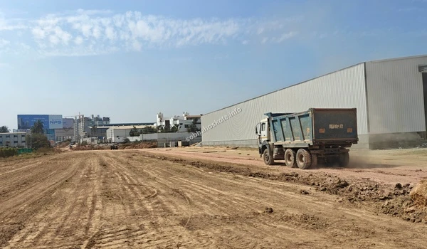 Large construction truck transporting essential building materials across the leveled site at Sobha Hoskote