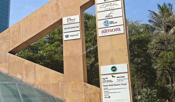 Street view of the office campus entry showing pedestrian walkways and green landscaping near Sobha Hoskote