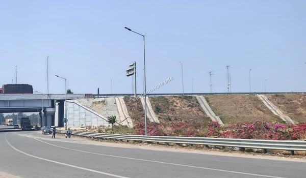 Close-up view of the structural elevation and landscaped embankments of the overbridge providing direct connectivity to the Sobha Hoskote project site