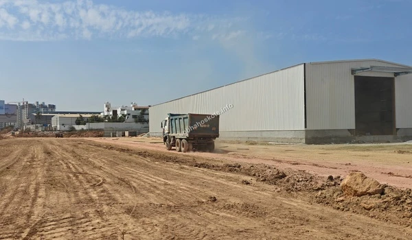 View of the leveled terrain showing the clear transition between the Sobha Hoskote project site and the adjacent boundary walls