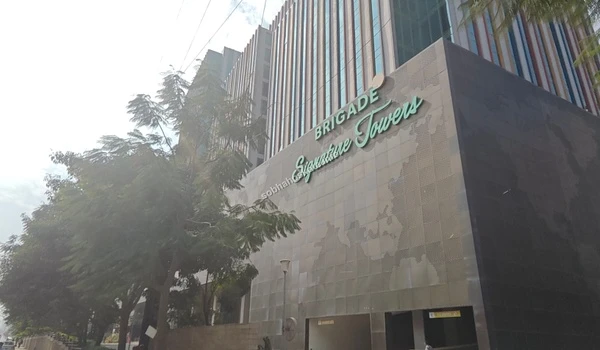 Low angle view of the Brigade Signature Towers entrance facade showing the modern glass architecture near Sobha Hoskote