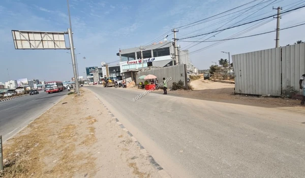 A closer look at the access point toward the Sobha Hoskote site office with construction materials and temporary structures visible