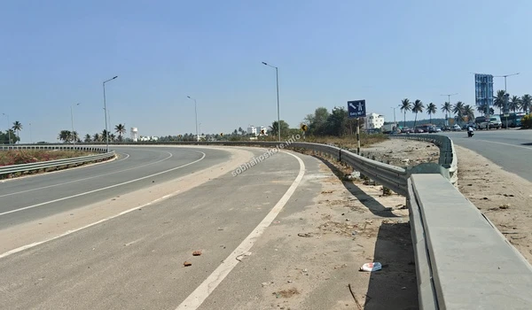 The wide curve of the Satellite Town Ring Road (STRR) interchange, highlighting the seamless connectivity and high-speed transit routes for Hoskote residents