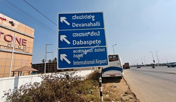A roadside perspective of the STRR towards Devanahalli featuring a white car on the expressway, demonstrating smooth transit near Sobha Hoskote