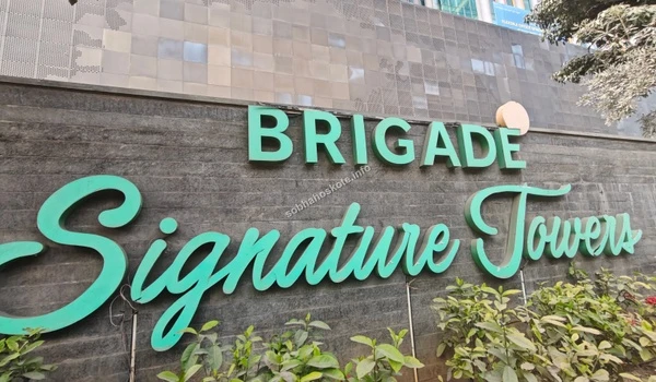 The iconic green and white signage of Brigade Signature Towers welcoming professionals near the Sobha Hoskote area