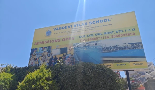 Large promotional billboard for Vagdevi Vilas School highlighting amenities like a swimming pool near Sobha Hoskote
