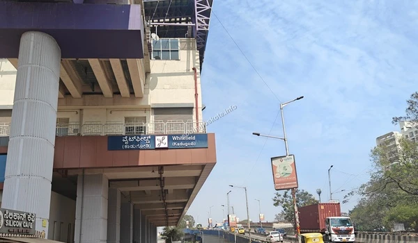 Daytime shot of the Whitefield (Kadugodi) metro station building and the adjacent flyover and roadway in Bangalore.
